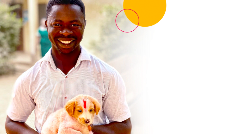 African man holding a puppy for world rabies day