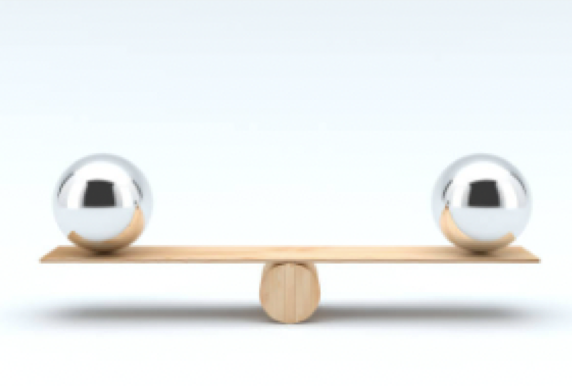 Two balls balancing on a plank of wood