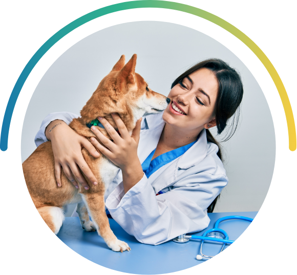 A veterinarian embracing a medium-sized, short-haired dog.